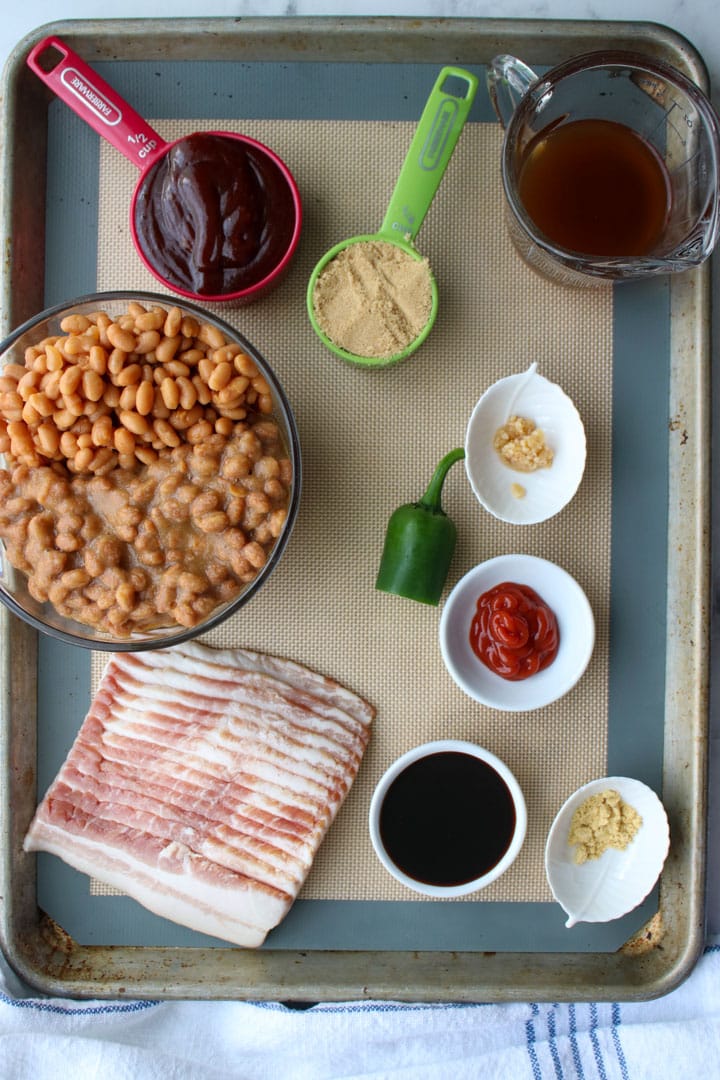 ingredients to make baked beans displayed on a baking sheets
