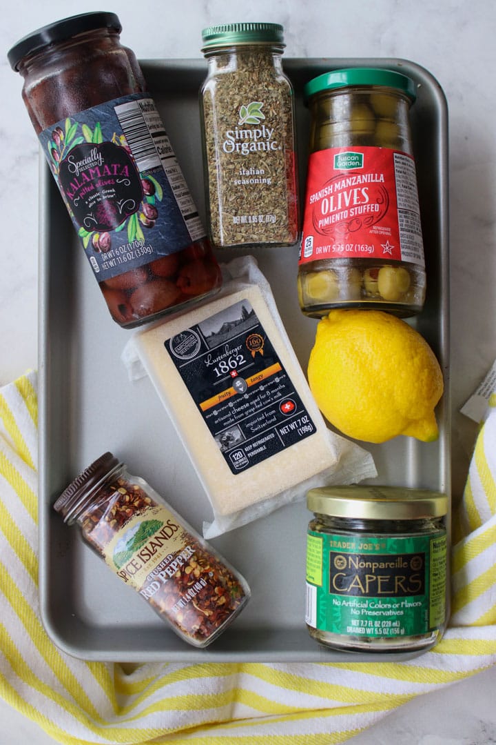 tray of ingredients to make marinated manchego cheese and olives