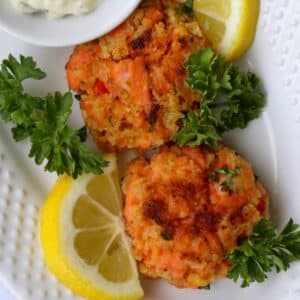 close up shot of two salmon patties on a white plate