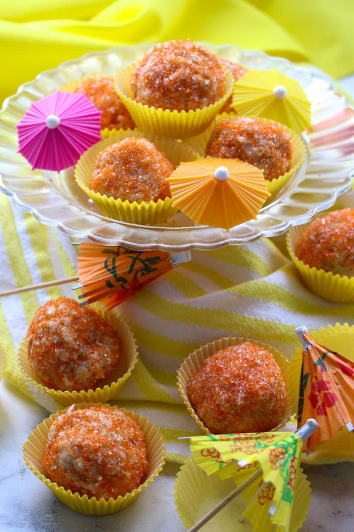 NO-BAKE TROPICAL COOKIE BALLS ON A PLATE IN COOKIE PAPERS