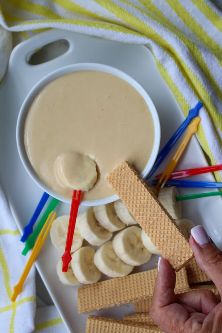 Whipped Cottage Cheese Caramel Dip in a bowl surrounded by cookies and sliced bananas