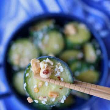 chop sticks holding 1 cucumber slice