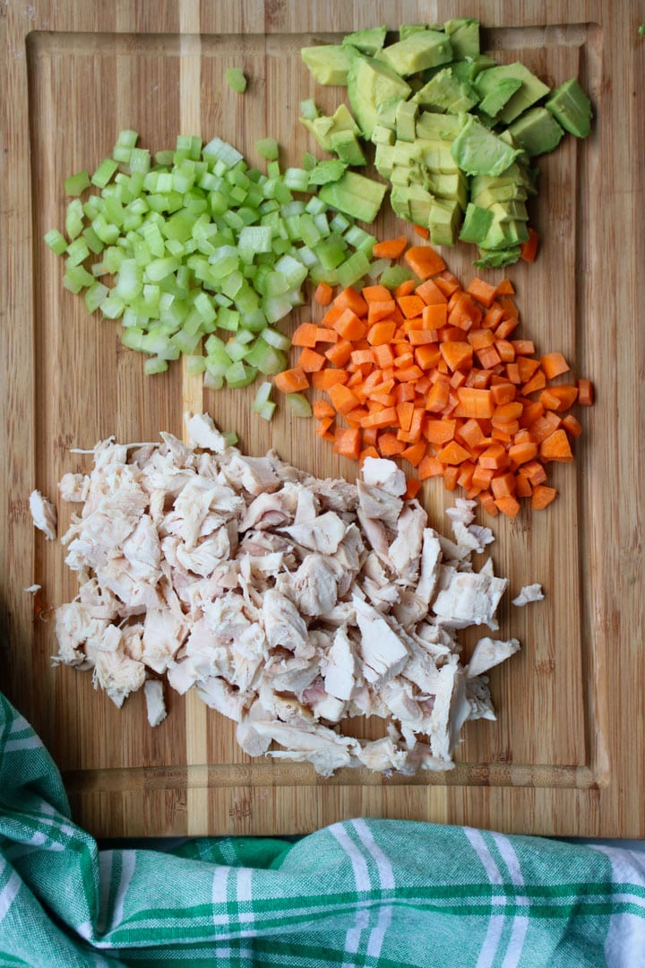 cutting board with diced chicken, diced carrots, diced celery