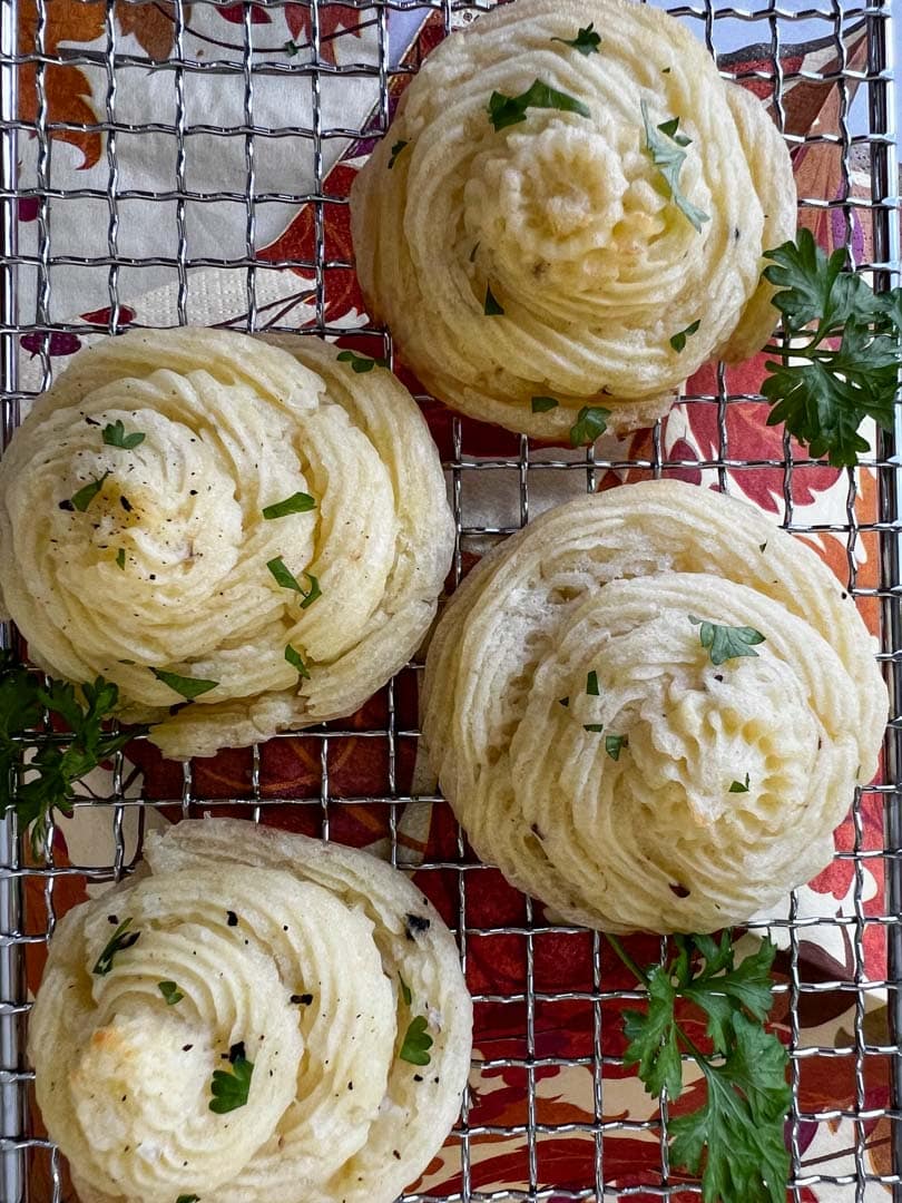 four duchess potatoes on a cooling rack