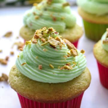 cupcake with a swirl of pistachio buttercream and pistachios