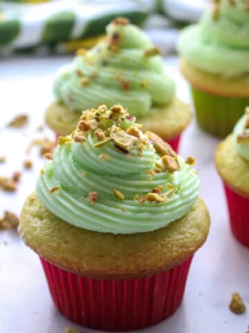 cupcake with a swirl of pistachio buttercream and pistachios