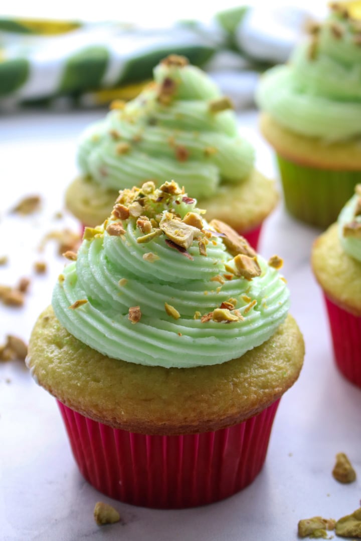 cupcake with a swirl of pistachio buttercream and pistachios