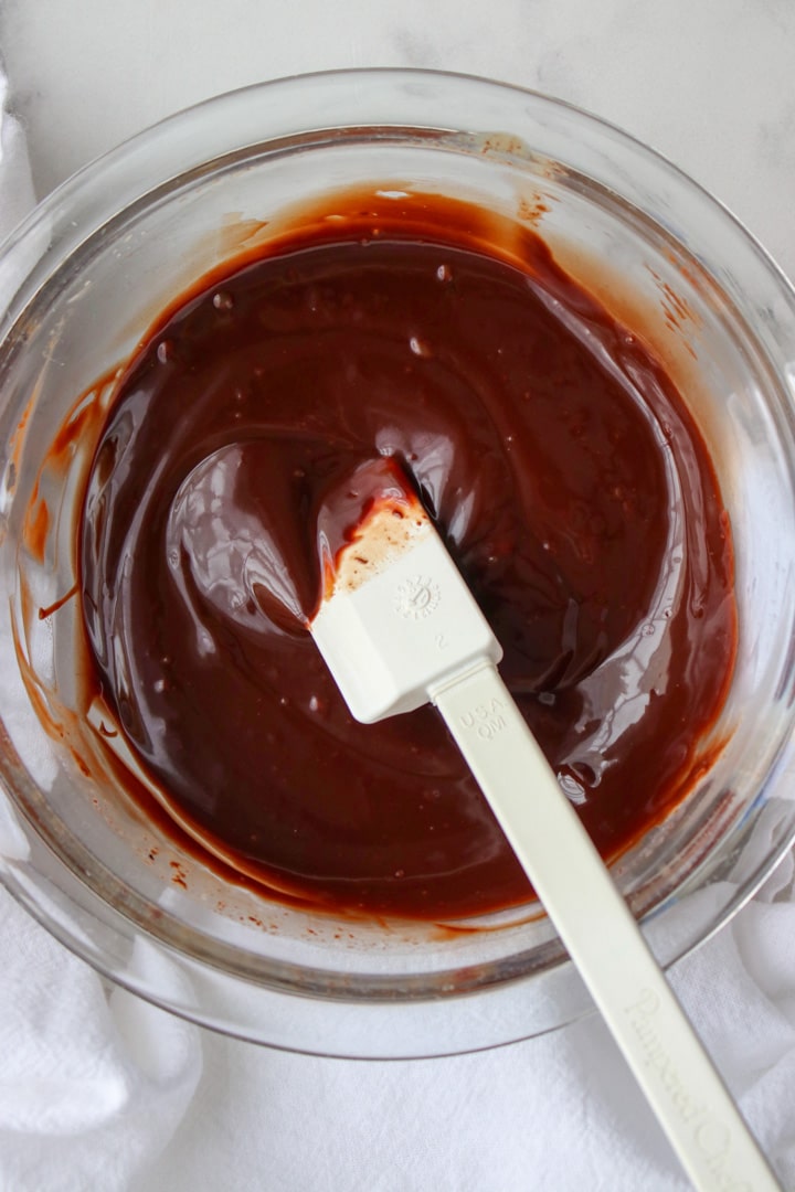 bowl of chocolate ganache with a spatula  in it