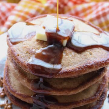 Stack of pancakes with syrup being drizzled on top