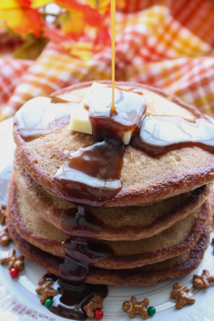 Stack of pancakes with syrup being drizzled on top