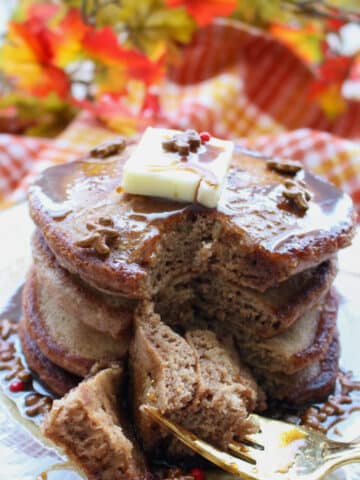 stack of gingerbread pancakes with a fork full cut out