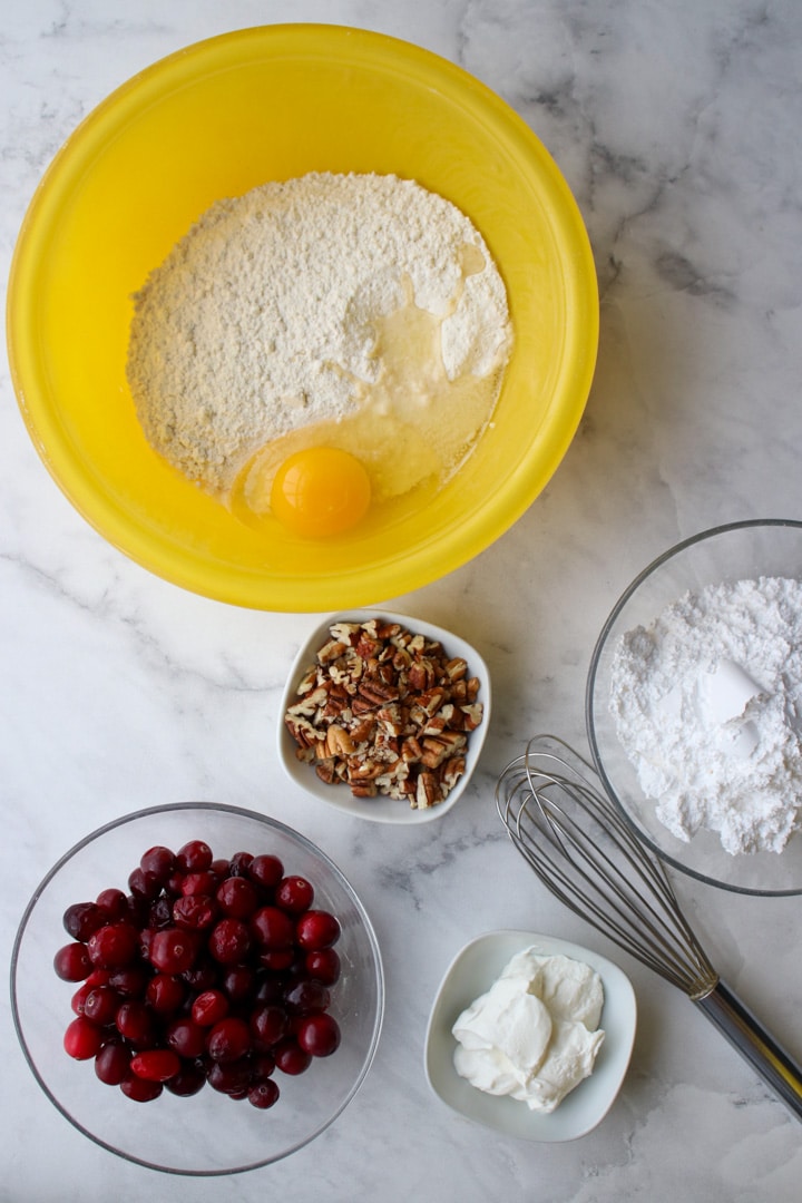 yellow bowl with the ingredients needed to make baked cranberry pancakes with cranberry glaze