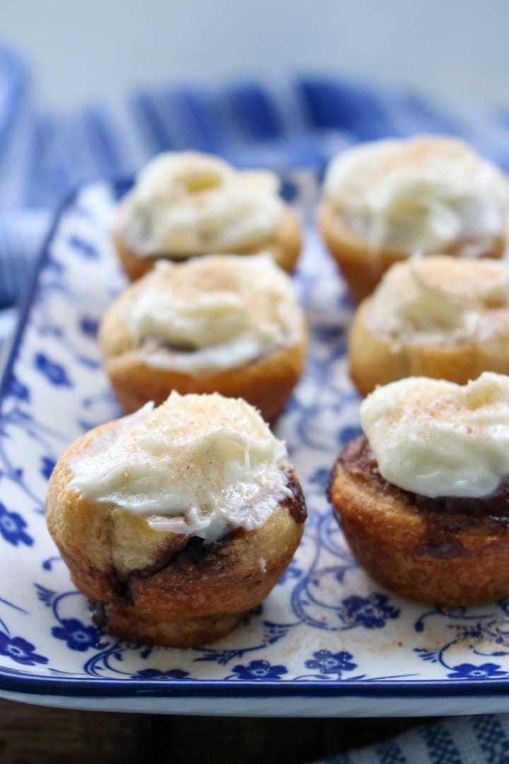 a plate of mini cinnamon rolls with cream cheese frosting