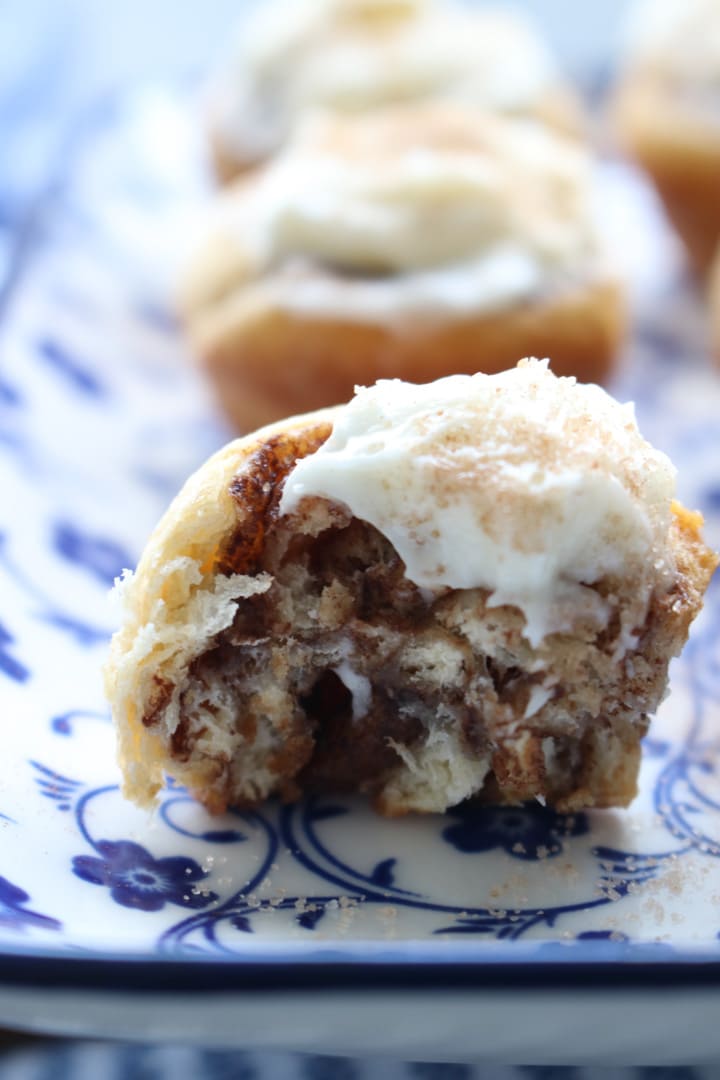 mini cinnamon roll with a bit taken out of it to expose the inside