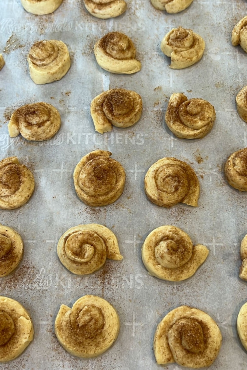 mini orange rolls on a baking sheet ready to go into the oven