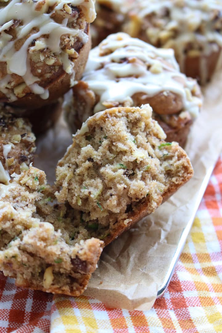 a close up of a pumpkin spice zucchini walnut muffin sliced in half