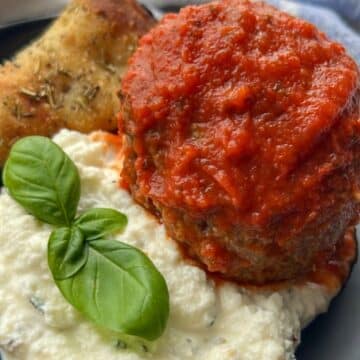 meatball on a plate with herbed ricotta and pizza bread