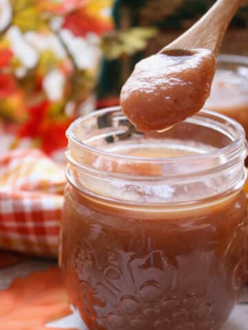 jar of apple butter with a small wooden spoon