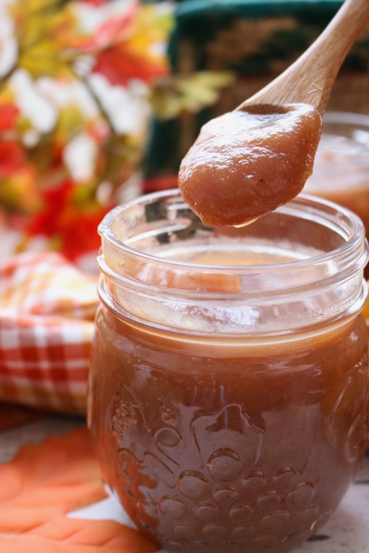 jar of apple butter with a small wooden spoon