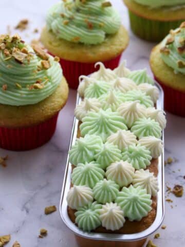 cake and cupcakes frosted with pistachio buttercream