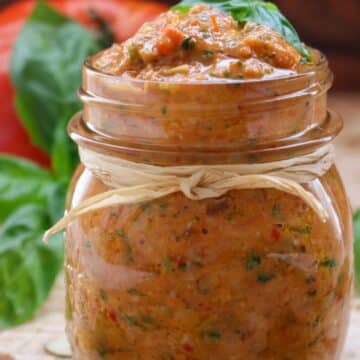 A jar of tomato pesto with a brown string wrapped around the jar