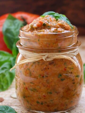 A jar of tomato pesto with a brown string wrapped around the jar