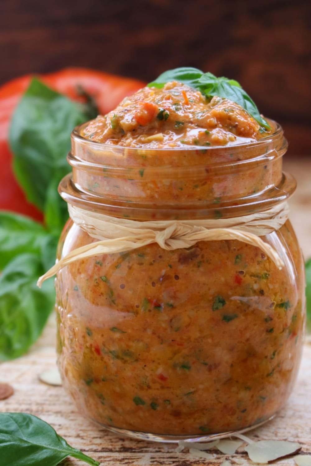 A jar of tomato pesto with a brown string wrapped around the jar