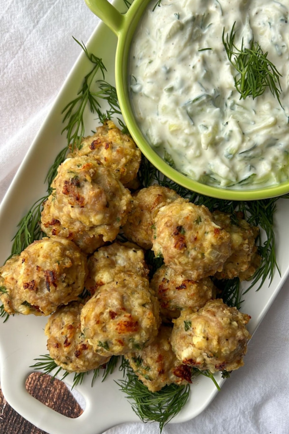 platter of chicken feta meatballs with a side of tzatziki sauce