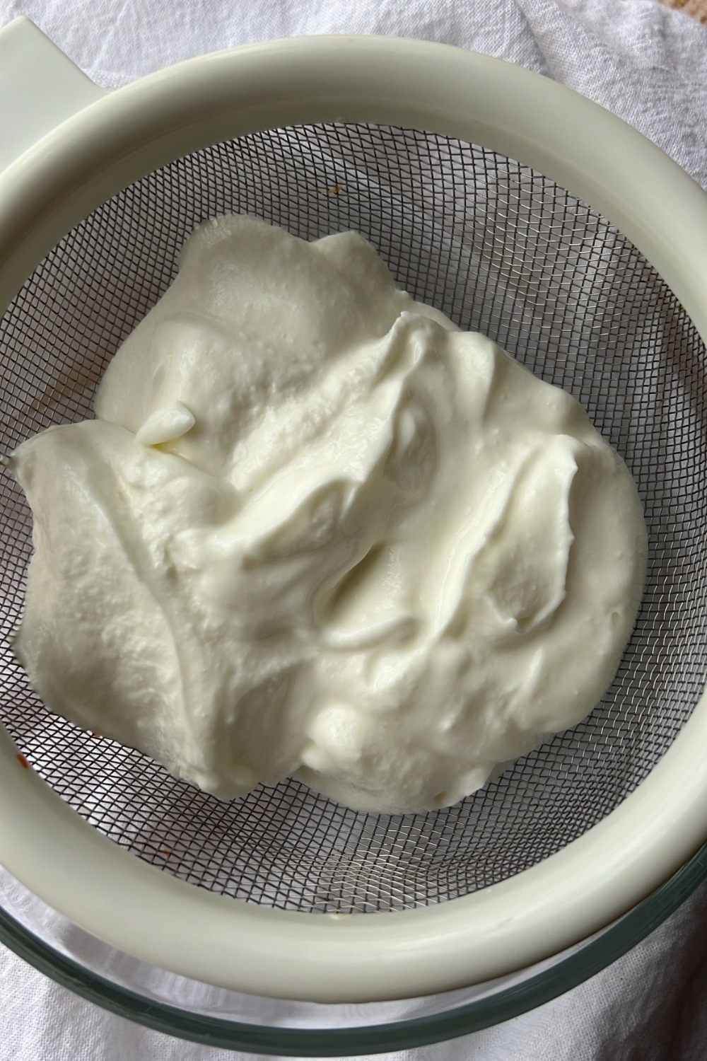 GREEK YOGURT IN A STRAINER. STRAINER IN A BOWL.