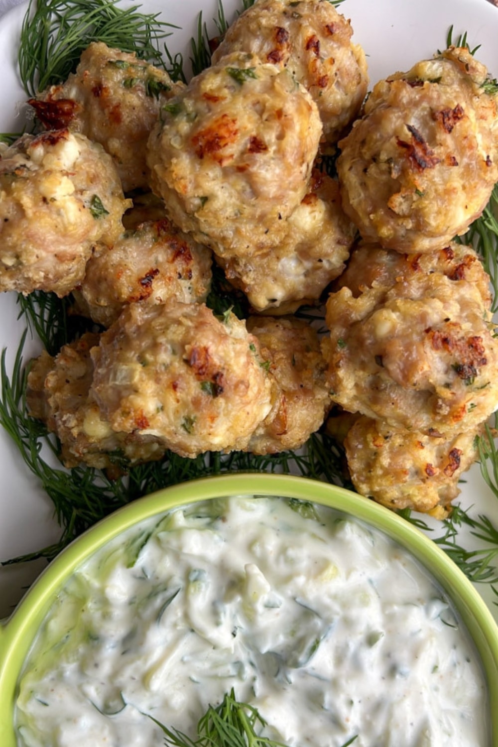 chicken feta meatballs with a bowl of taztiki sauce