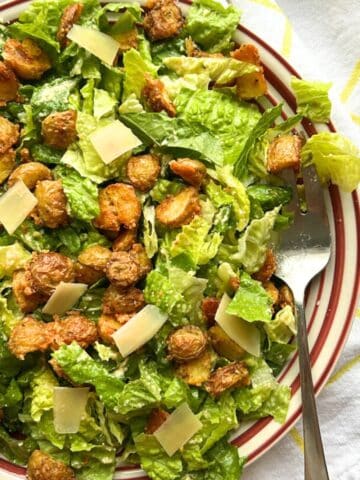 bowl of Crispy Parmesan Potato Caesar Salad with a spoon on the right side