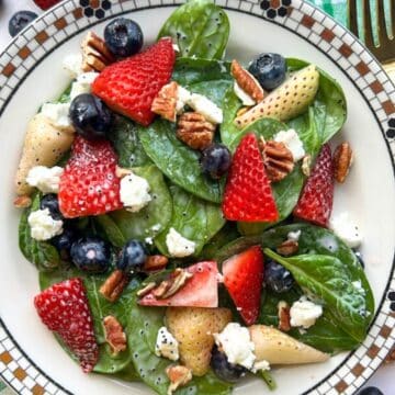 bowl of red white blue spinach berry salad