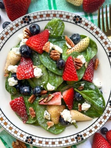 bowl of red white blue spinach berry salad