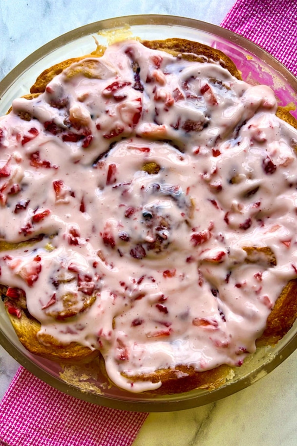 overhead shot of strawberry rolls with strawberry cream cheese frosting