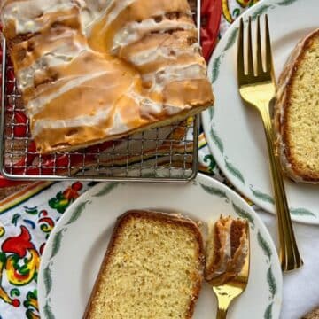 Orange loaf cake with two slices on a plate.