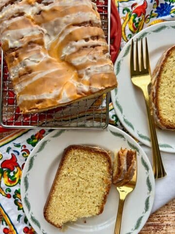 Orange loaf cake with two slices on a plate.
