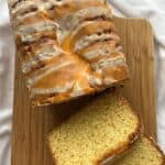 orange loaf cake on a cutting board with two slices laying down