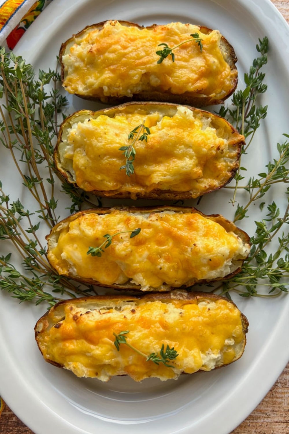 platter of air fryer twice baked potatoes surrounded by fresh thyme sprigs
