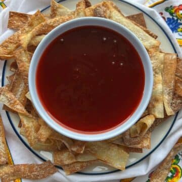 bowl of sweet and sour sauce with wonton chips