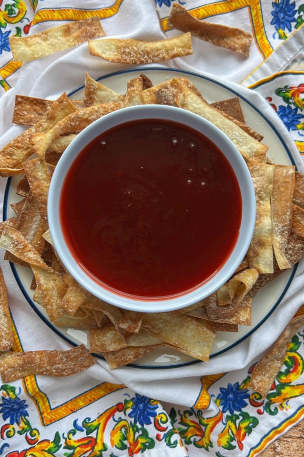 bowl of sweet and sour sauce with wonton chips