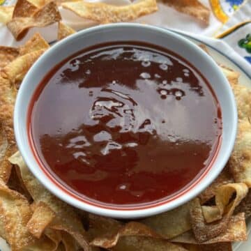 bowl of sweet and sour sauce with wonton chips