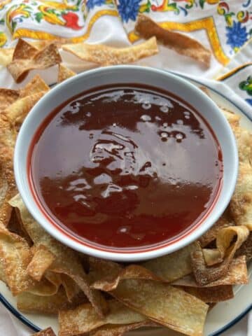 bowl of sweet and sour sauce with wonton chips