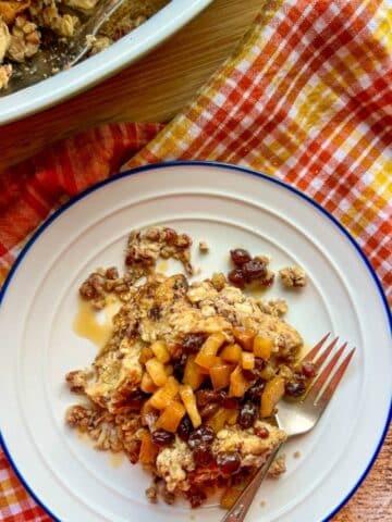 apple raisin french toast on a plate next to the casserole dish used to bake it