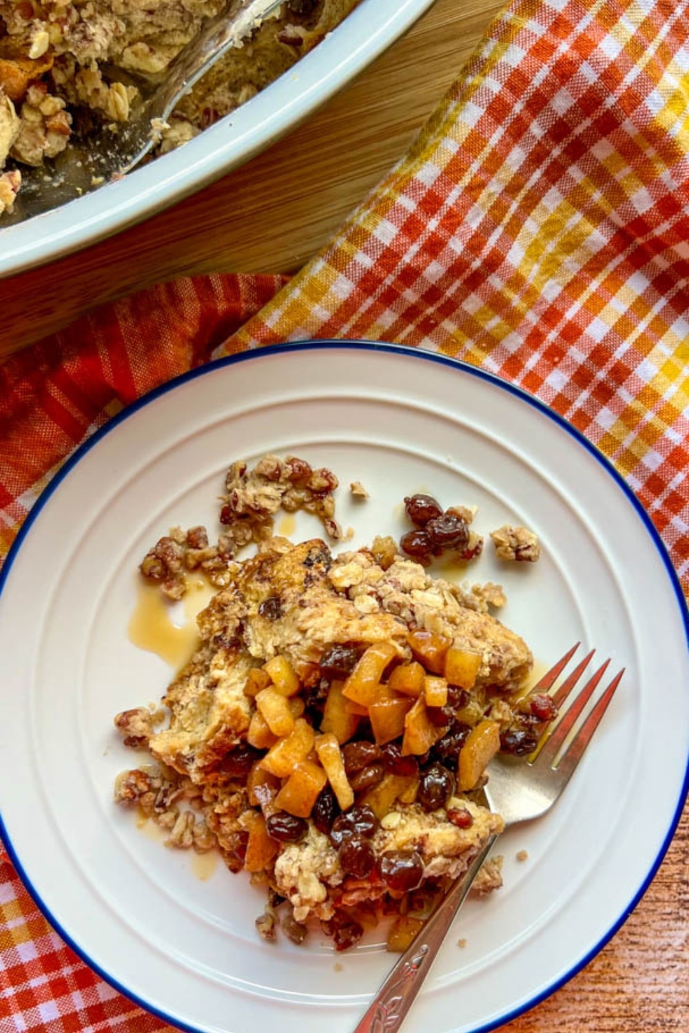 apple raisin french toast on a plate next to the casserole dish used to bake it