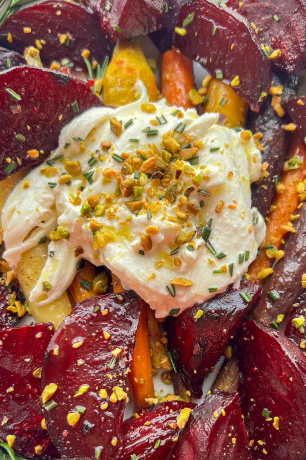 close up of a platter of honey maple roasted beets and carrots with burrata cheese