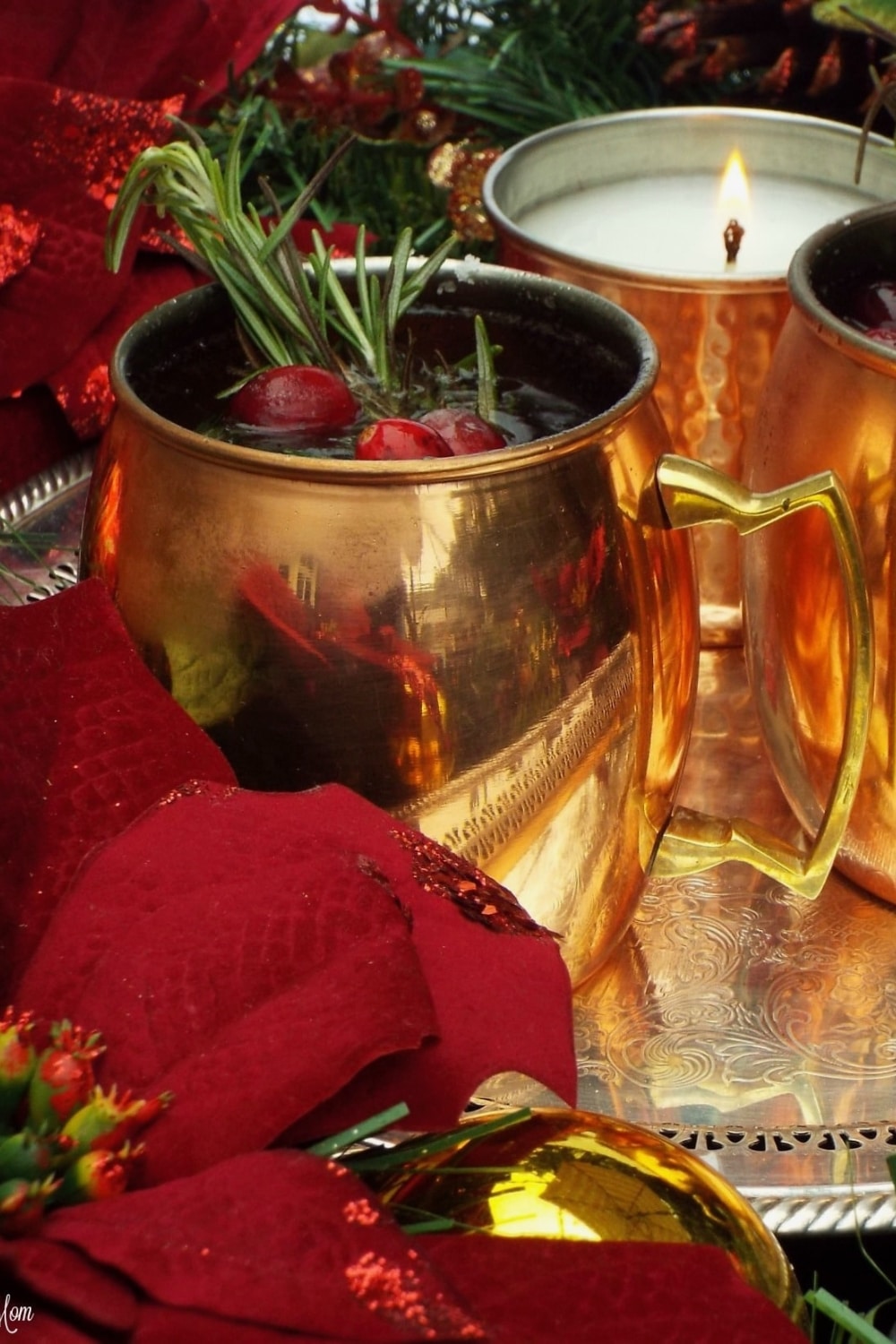 Merry mule cocktail in a mule glass garnished with rosemary and cranberries