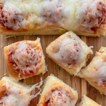 Sliced Hawaiian roll meatball sliders on a cutting board.