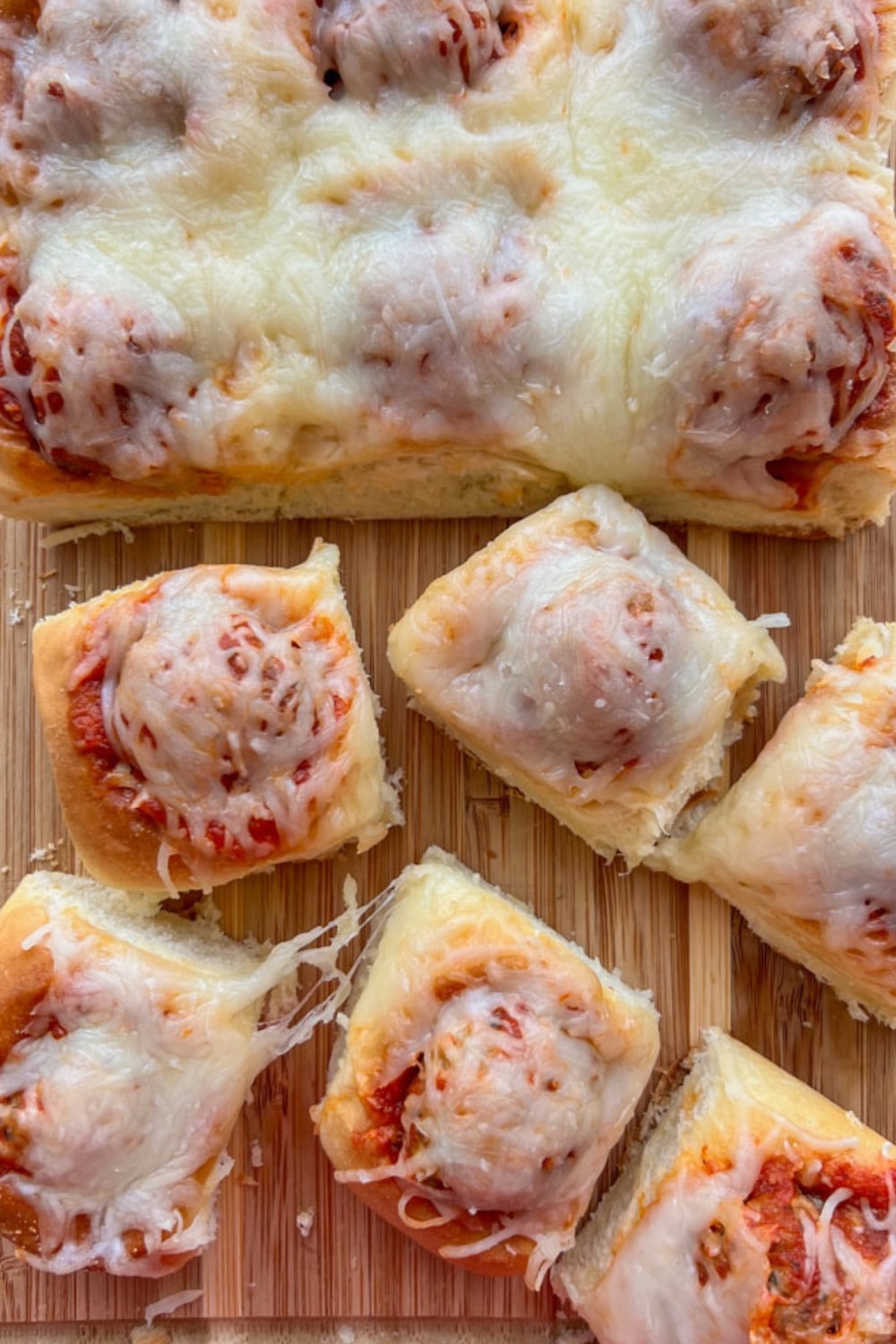 Sliced Hawaiian roll meatball sliders on a cutting board.