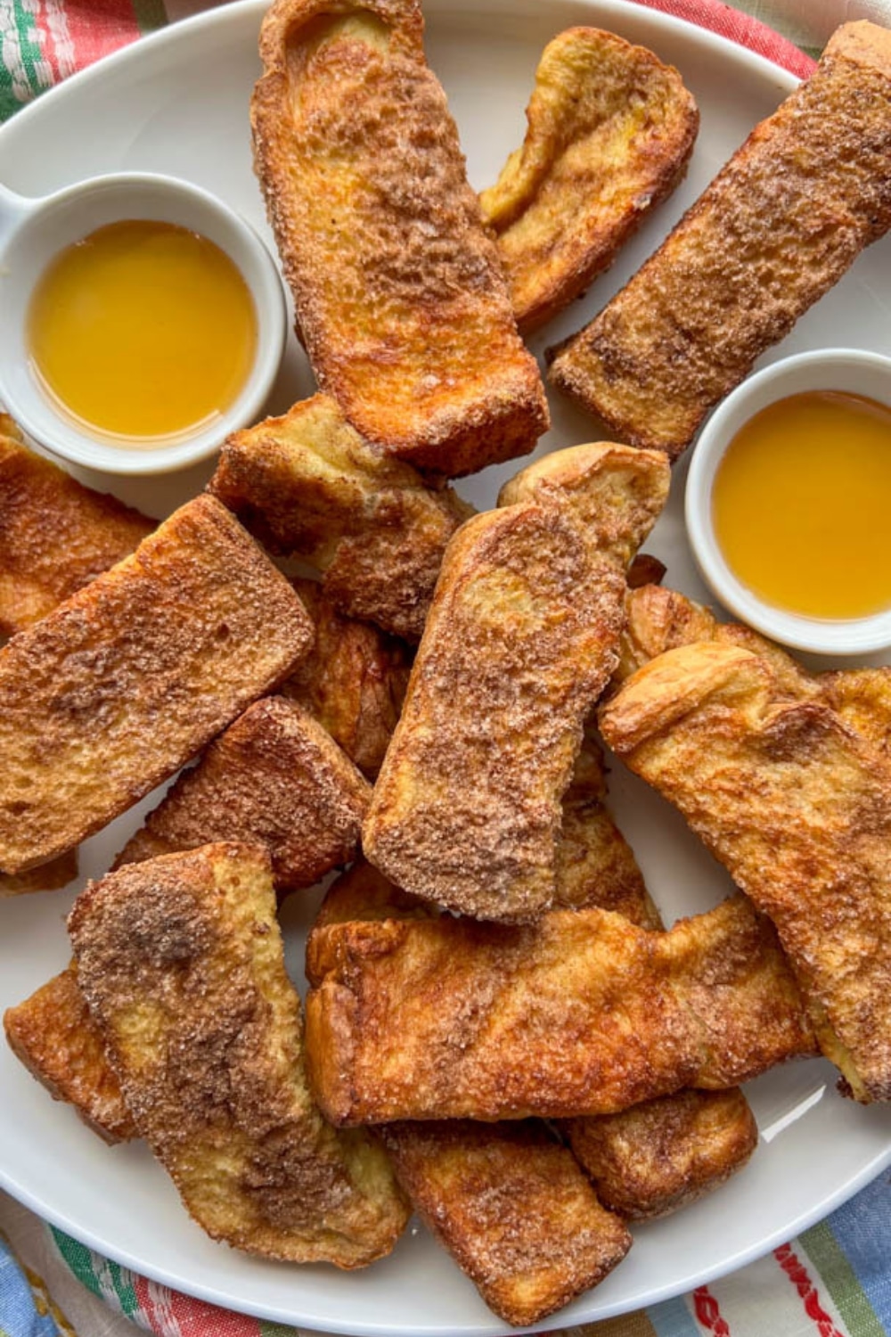 Air Fryer French Toast Sticks on a platter with syrup dipping sauce
