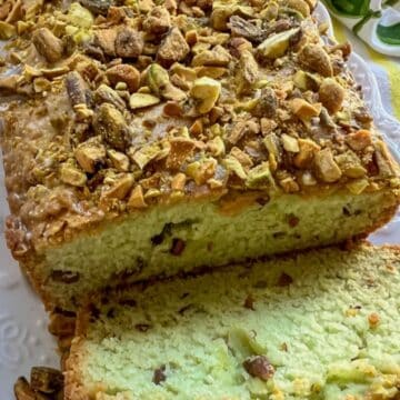 loaf of pistachio olive oil bread with one slice cut off